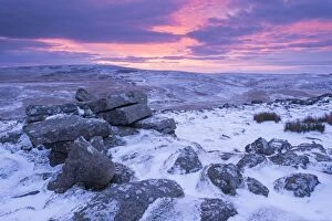 Beautiful sunrise over a frozen and snow covered Belstone Tor, Dartmoor National Park