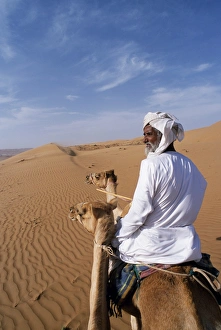 Nomad Prints: A Bedu rides his camel in the desert