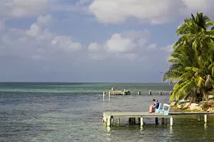 Images Dated 2nd April 2008: Belize, Tobaco Caye, Tourists sitting on pier reading