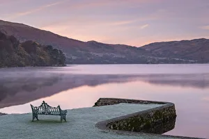 Bench on Ullswater at dawn on a frosty winter morning, Lake District, Cumbria, England