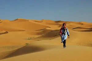 Sahara Prints: Berber man walking in the Erg Chebbi sand dunes, Sahara Desert, Merzouga, Morocco
