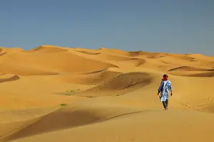 Sahara Prints: Berber man walking in the Erg Chebbi sand dunes, Sahara Desert, Merzouga, Morocco