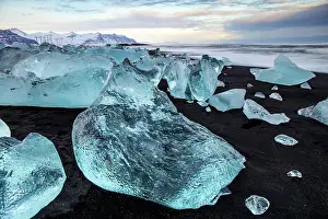 Southeast Iceland Prints: Black volcanic sand beach covered in icebergs from Jokulsarlon glacier lagoon at dawn