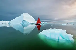 Danish Territory Prints: Blue iceberg and red sailboat in Disko Bay, Greenland