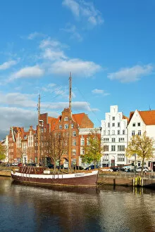 Gable Gallery: Boat anchored on Trave river and houses with traditional gables in background, Lubeck, UNESCO