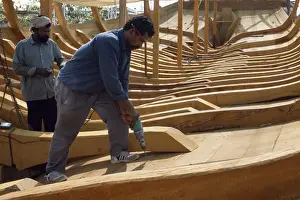 Craftsman Prints: Boat builders constructing a large dhow in the boat yard at Sur