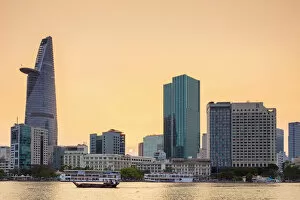 Saigon Gallery: A boat passes by central Ho Chi Minh City (Saigon) skyline on the Saigon River at sunset