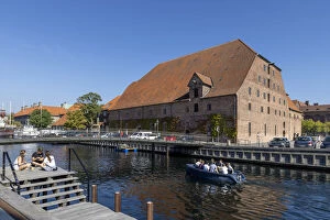 A boat passes a converted warehouse on a canal near the city centre, Copenhagen, Zealand