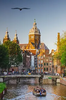 Urban Landscape Prints: A boat with tourists in the water canal with St. Nicholas church reflecting in the canal