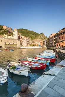 Boats in the colourful port and Santa Margherita di Antiochia church