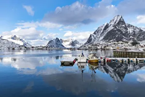 Reine Prints: Boats in the harbour, with Olstinden peak in the background in winter