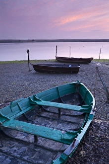 Boats at low tide on the shore of The Fleet lagoon, Chesil Beach, Dorset, England. Spring