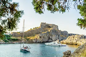 Acropolis Of Lindos Gallery: Boats at St Pauls Beach and The Acropolis of Lindos in the background, Lindos, Dodecanese Islands