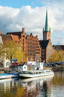 Lubeck Prints: Boats on Trave river, traditional houses and St Petri Lubeck Church in background