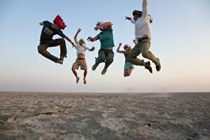 Activity Gallery: Botswana, Makgadikgadi. A family jump high in the air above the Makgadikgadi salt pans