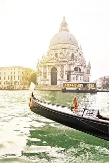Canal Prints: Bow of a gondola sailing in the Venetian Lagoon with Santa Maria della Salute Basilica on background