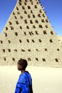 Religious Site Prints: Boy walking along the Sankore mosque, a UNESCO World Heritage Site. Timbuktu, Mali