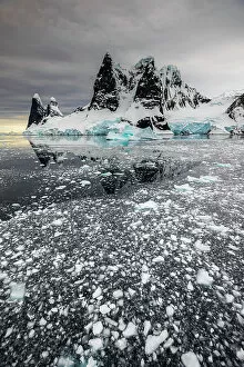 Antarctica Gallery: Brash ice floating below Una Peaks at False Cape Renard, Lemaire Channel, Antarctica