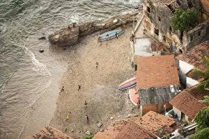 Brazil, Bahia, Salvador, locals playing football on the beach in a favela (slum community)