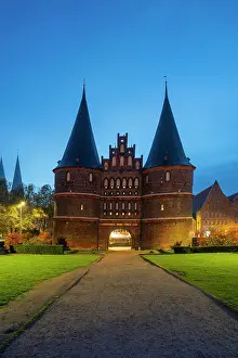 Brick Gothic Prints: Brick-built Medieval gate to Lubeck named Holstentor at twilight