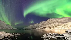 Aurora Borealis Prints: Bright night sky with Northern Lights over snowcapped mountains and frozen sea of Ersfjorden