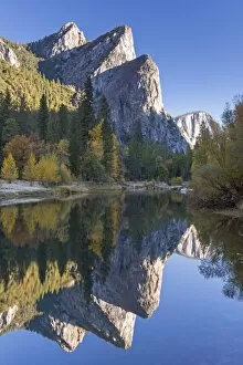The Three Brothers reflected in the Merced River at dawn, Yosemite Valley, California, USA