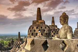 Buddha statue at sunset, Candi Borobudur buddhist temple, Muntilan, Java, Indonesia