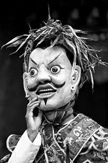 Bhutan Prints: Buddhist monk wearing ancient wooden mask during a performance at the Wangdue Phodrang Tsechu