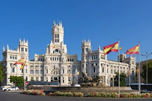 Fountain Prints: Building of Plaza de Cibeles at traffic circle against blue sky, Madrid, Spain