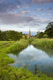 Burford Church spire reflected in the River Windrush watermeadows, Burford, The Cotswolds