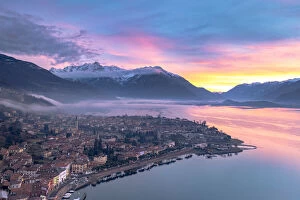 Pink Gallery: Burning sky at dawn over the snowcapped mountains and Domaso old town, aerial view