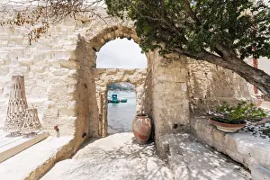 Favignana Prints: Camparia, Favignana, Italy. Boats in harbor viewed through stone archway