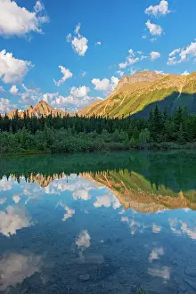 Canadian Rocky Mountains reflected in a pond in the Silverhorne Creek Campground. Icefields Parkway. Capricorn Mountain at left, Aires Peak at center followed by the two small peaks of Midway Peak and Mt. Synge at far right