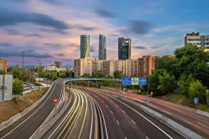 Highway Prints: Car light trails on urban highway with Four Towers Business district in Paseo de la Castellana