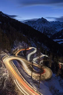 Images Dated 23rd February 2016: Car lights on the curvy Maloja Pass road at night. Maloja Pass, Engadin, Graubunden