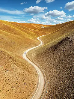 Brown Prints: Car on track among colorful slopes, Vega de los Colorados, Puna, Catamarca, Argentina