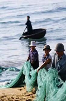 Indo China Gallery: Carrying fishing nets up the beach after the days work