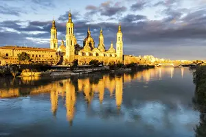 Cathedral of Our Lady of the Pillar reflected in Ebro river at sunrise. Zaragoza, Aragon
