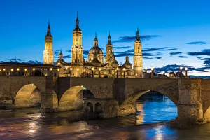 Zaragoza Prints: Cathedral of Our Lady of the Pillar and stone bridge at dusk. Zaragoza, Aragon, Spain