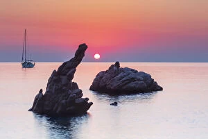 Images Dated 17th September 2020: Cefalu, Sicily. Sun rising beyond the rock formations at Kalura beach near Cefalu
