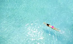 Rippled Prints: Central America, Belize, Cayo, a girl in a pink bikini swimming in a blue swimming pool