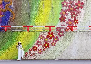 Ceramic flower mosaic mural and woman in traditional Ao Dai dress, Hanoi, Vietnam
