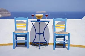 South Aegean Prints: Chairs and table with two glasses of red wine against sea, Santorini, Cyclades