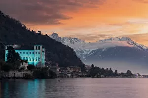 Charming old building Palazzo Gallio and snowy peaks at sunrise during Christmas time
