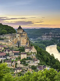 Chateau de Castelnaud castle and village over Dordogne River valley at sunset