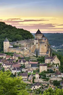 Chateau de Castelnaud castle and village over Dordogne River valley at sunset