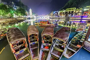 China, Hunan province, Fenghuang, traditional bamboo rafts and riverside houses reflecting