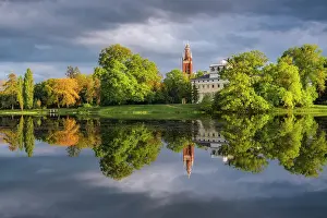 Church, castle and deciduous trees reflected in the lake Worlitz, Dessau-Worlitzer Garden Realm, English style landscape park, Unesco World Heritage site, Dessau-Worlitz, Saxony-Anhalt, Germany