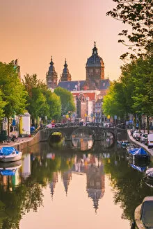 Amsterdam Gallery: Church of St Nicholas reflecting in the canal at sunrise on a summer evening in Amsterdam