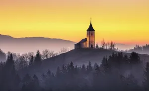 Church Of St Prints: Church of St. Primoz and Felician against a golden sky at dawn